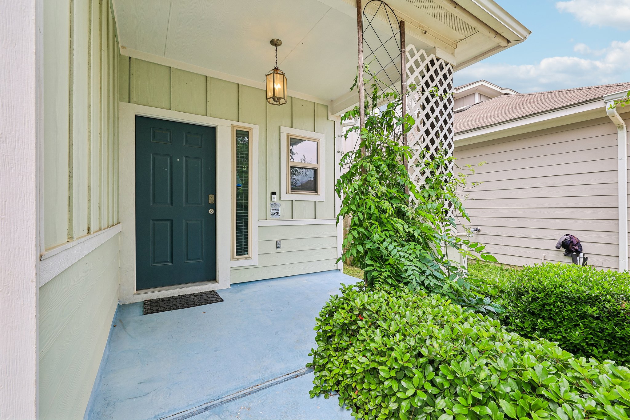 387 Guemal Road Buda, TX 78610 - Photo 2 of 39 Front entry featuring a dark-paneled door, sidelight window, and an overhead pendant light fixture