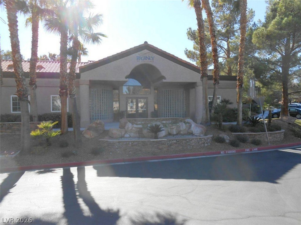 9325 West Desert Inn Road, Unit 132 Las Vegas, NV 89117 - Photo 32 of 36 A welcoming entry with mature palm trees frames this building's inviting facade.