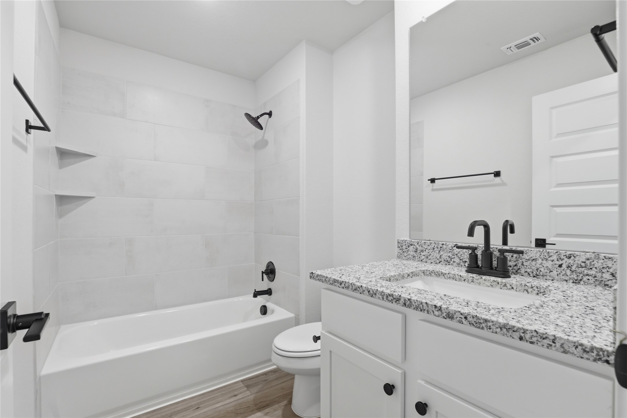 9320 Gladsome Path Manor, TX 78653 - Photo 16 of 34 a bathroom with a granite countertop sink a toilet and bathtub