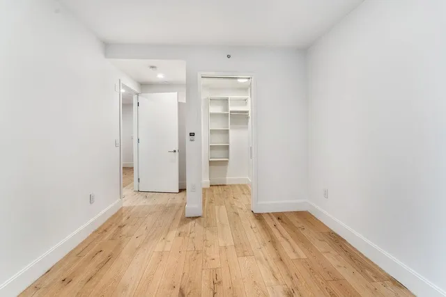 a view of a room with wooden floor and white walls