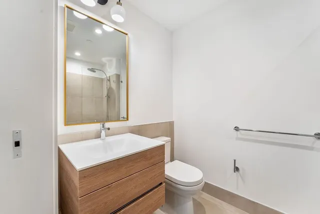 a bathroom with a sink mirror vanity and toilet