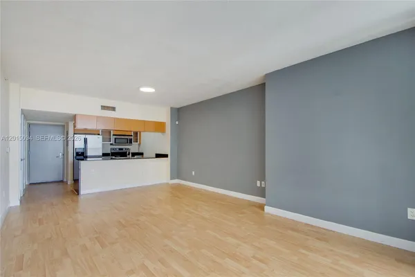 a view of a kitchen with a sink and a refrigerator