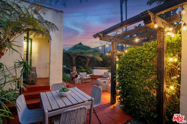 a view of patio with table and chairs and potted plants