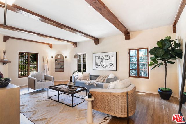 a living room with furniture potted plant and a large window