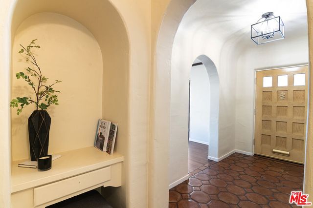 a view of a hallway with cabinet and a mirror