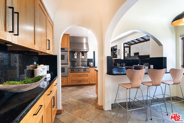 a kitchen with stainless steel appliances kitchen island granite countertop a table and chairs in it