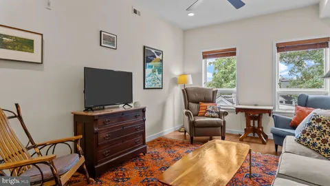 a living room with furniture and a dining table with wooden floor