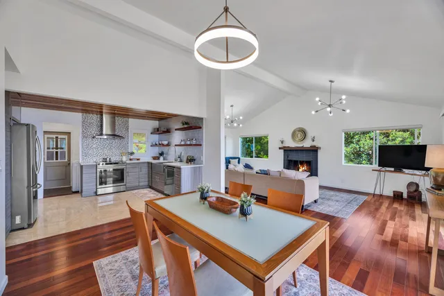 a living room with furniture a flat screen tv and kitchen view