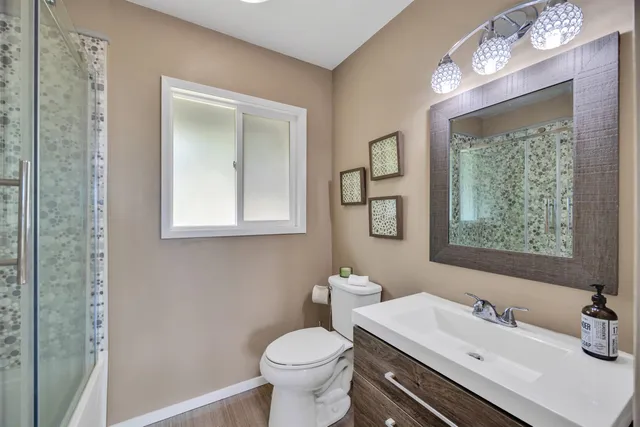 a bathroom with a sink a toilet and mirror