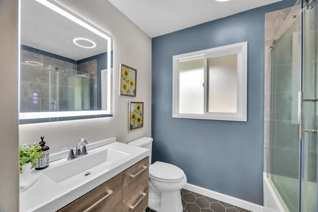 a bathroom with a sink a toilet and mirror