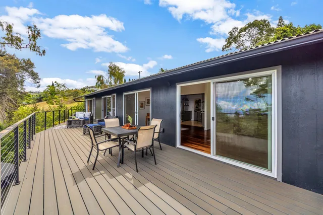 a view of a patio with table and chairs with wooden floor and fence