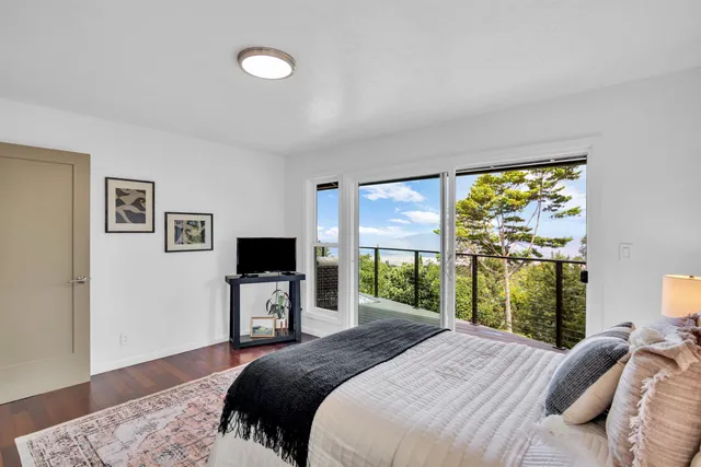 a bedroom with a large bed and a flat tv screen