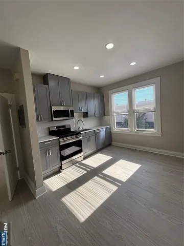 a kitchen with stainless steel appliances granite countertop a refrigerator and a stove top oven