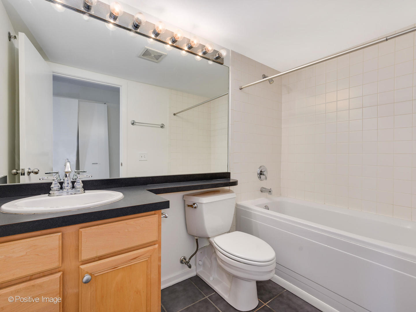 500 South Clinton Street, Unit 110 Chicago, IL 60607 - Photo 12 of 16 a bathroom with a granite countertop sink toilet and shower
