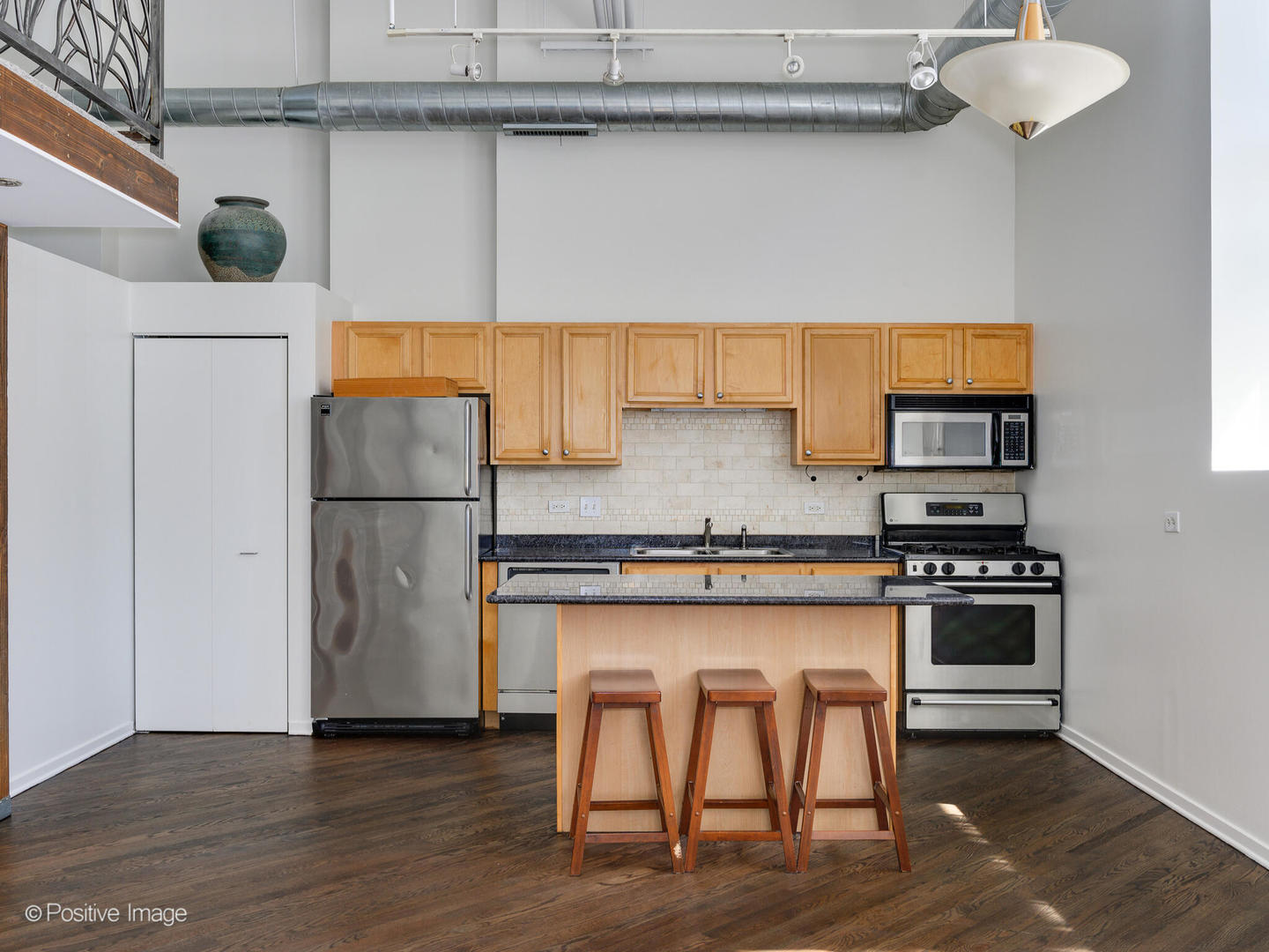 500 South Clinton Street, Unit 110 Chicago, IL 60607 - Photo 5 of 16 a kitchen with stainless steel appliances granite countertop a refrigerator and a stove top oven
