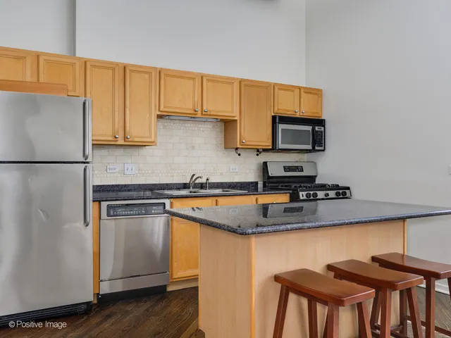 a kitchen with stainless steel appliances granite countertop a stove a sink dishwasher and a refrigerator