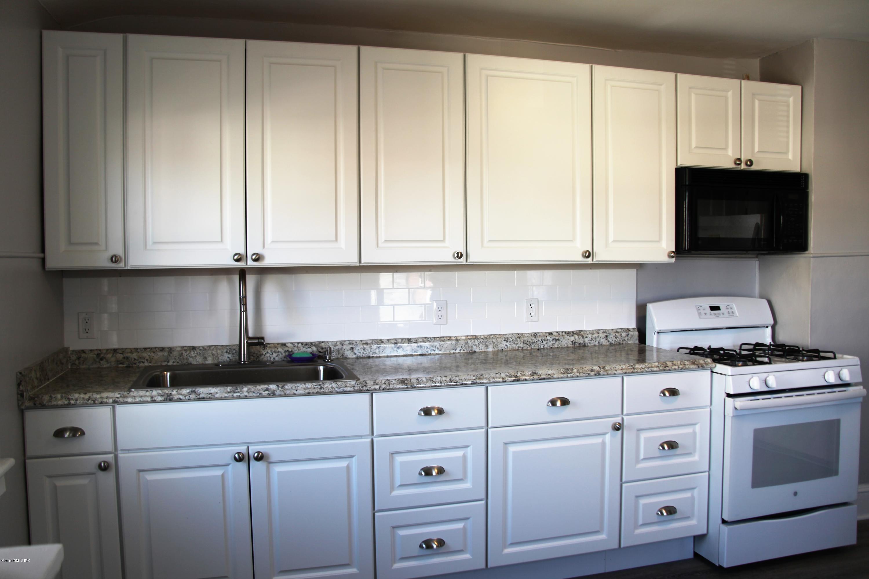 173 Hamilton Avenue Greenwich, CT 06830 - Photo 2 of 12 a kitchen with granite countertop white cabinets and a stove