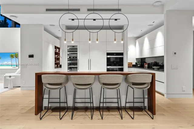 a kitchen with stainless steel appliances kitchen island granite countertop a table chairs in it and a window