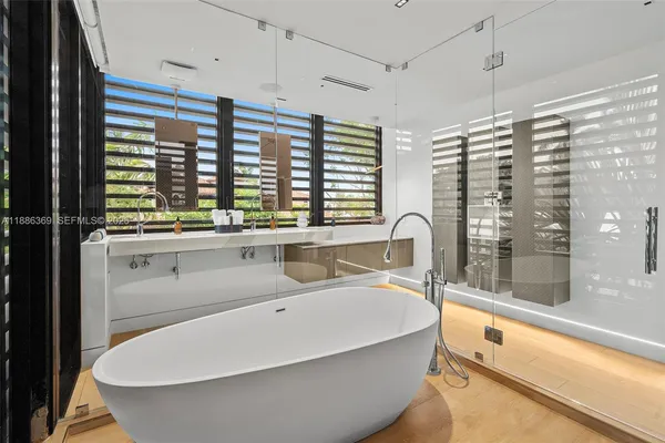 a bathroom with a shower sink vanity mirror and toilet