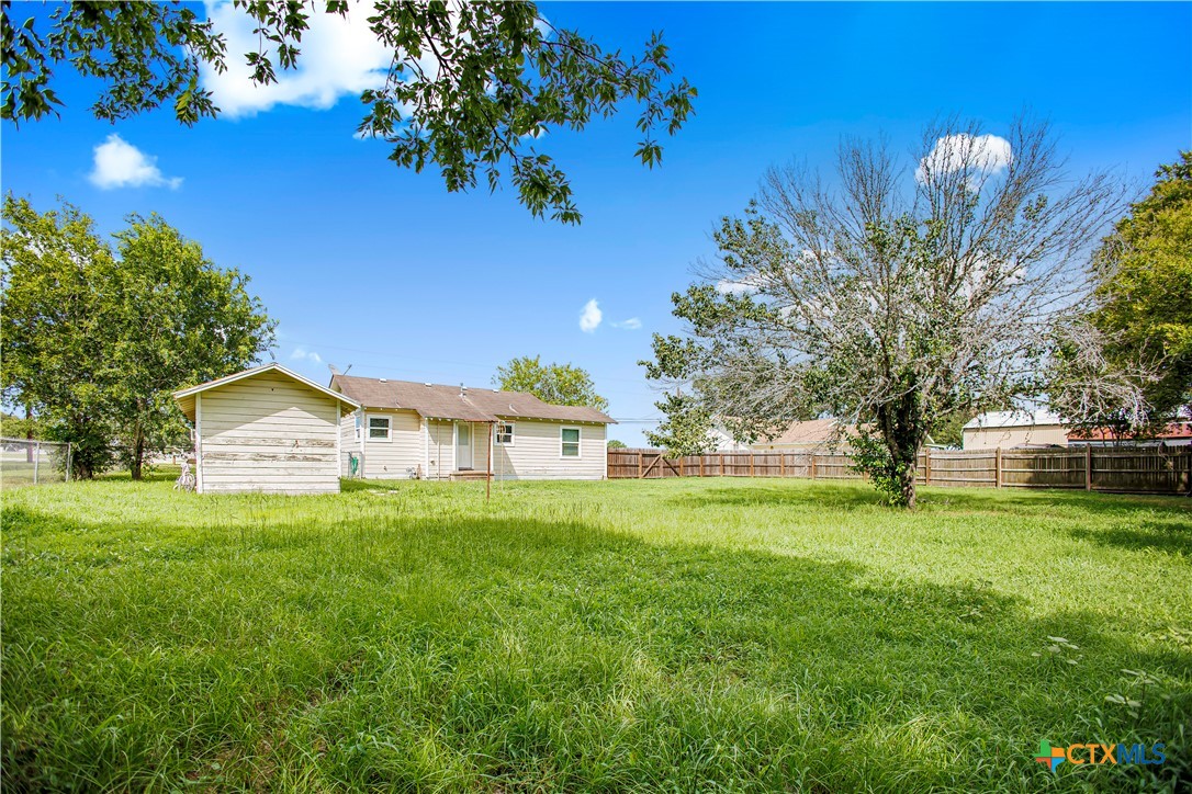 704 Maple Street Yoakum, TX 77995 - Photo 14 of 18 a view of a house with a big yard and large trees