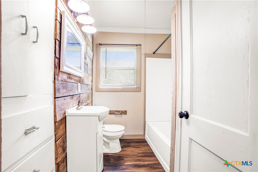 704 Maple Street Yoakum, TX 77995 - Photo 7 of 18 a bathroom with a toilet a sink and a mirror