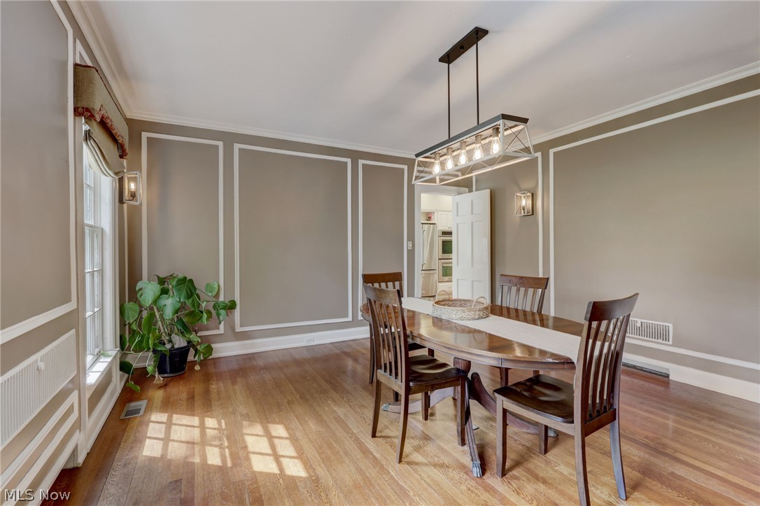 102 Wolcott Road Akron, OH 44313 - Photo 18 of 48 Dining area with a notable chandelier, ornamental molding, and wood-type flooring