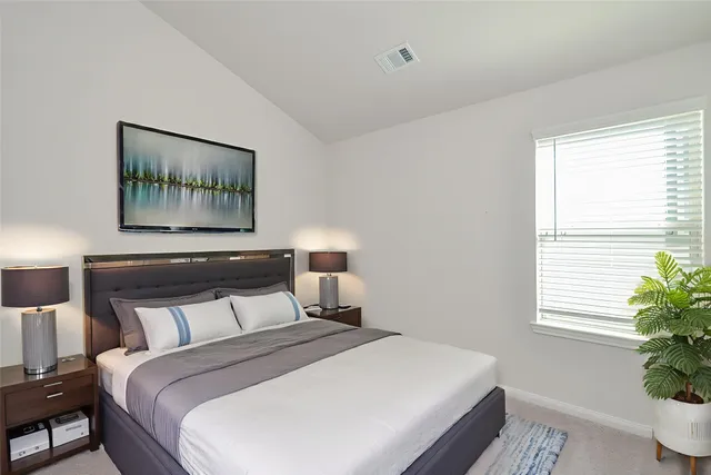 a bedroom with a bed and a painting on the wall