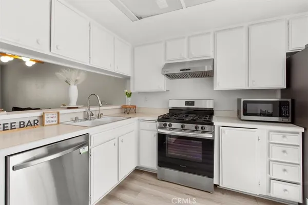 a kitchen with cabinets appliances a sink and a counter top