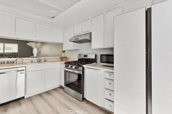 a living room with furniture kitchen view and a chandelier