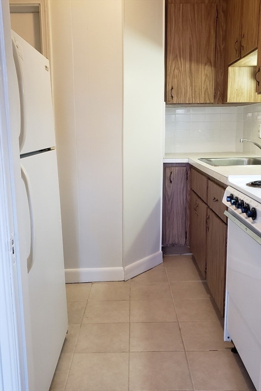 924 Beacon Street, Unit 6 Boston, MA 02215 - Photo 9 of 28 a kitchen with stainless steel appliances granite countertop a refrigerator and a stove