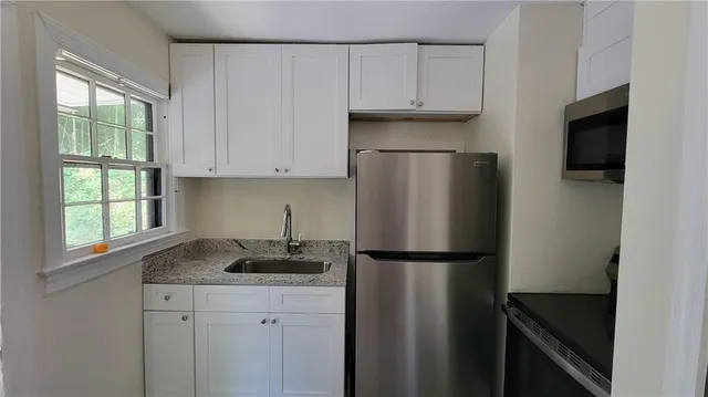 a kitchen with stainless steel appliances granite countertop a refrigerator sink and stove