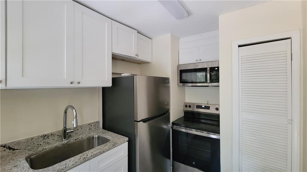 2267 Rugby Terrace Atlanta, GA 30337 - Photo 17 of 19 a kitchen with stainless steel appliances granite countertop a refrigerator sink and stove