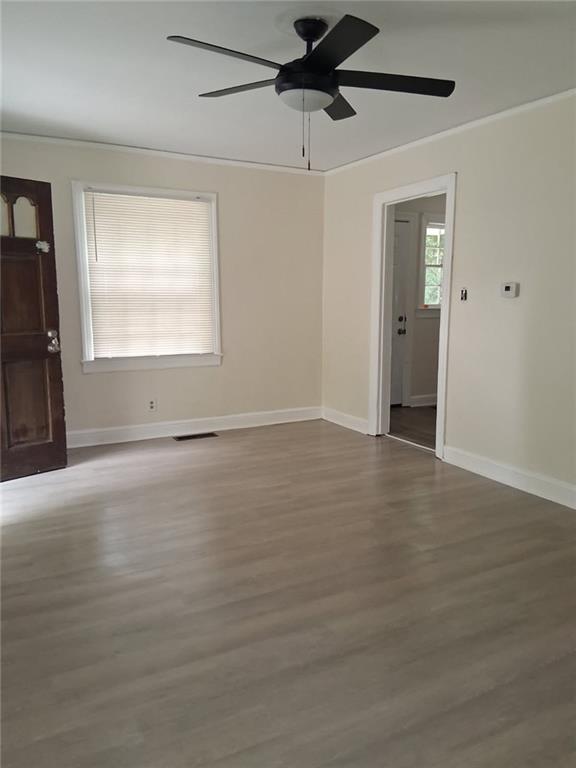 2267 Rugby Terrace Atlanta, GA 30337 - Photo 7 of 19 an empty room with wooden floor cabinet and windows