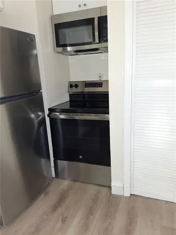 a view of a hallway with wooden floor and a living room