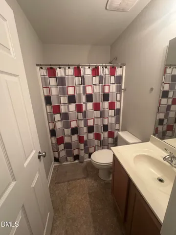 a bathroom with a sink a toilet and shower curtain