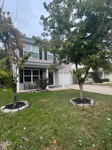 a front view of a house with a garden