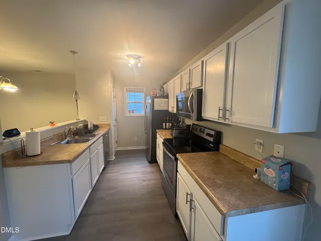 a kitchen with stainless steel appliances granite countertop a sink stove and cabinets
