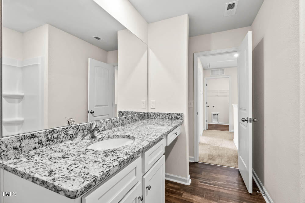 265 Crow Field Street Roxboro, NC 27574 - Photo 16 of 18 a bathroom with a granite countertop sink and a wooden floor