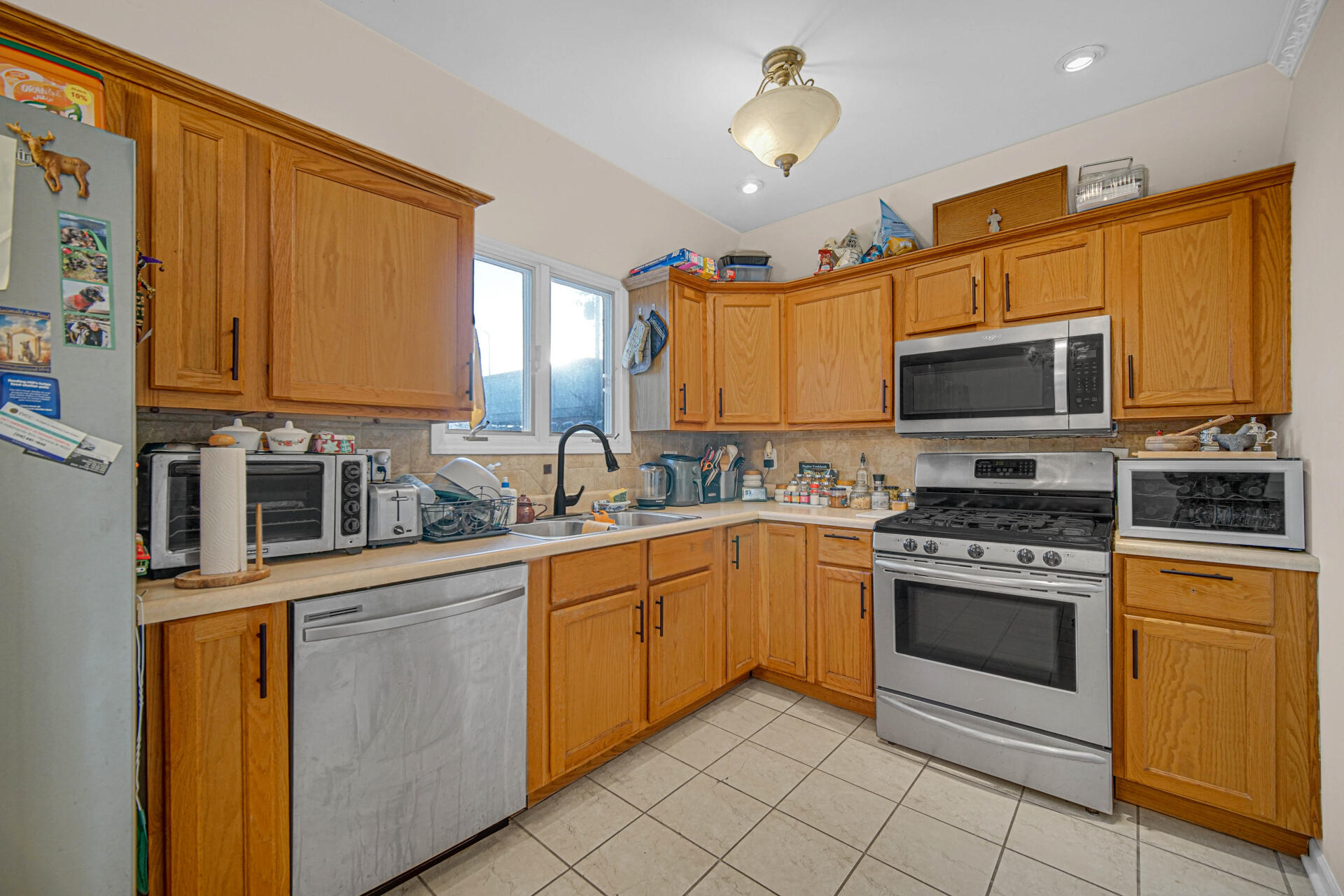 7933 Jefferson Avenue, Unit 4B Munster, IN 46321 - Photo 7 of 20 a kitchen with stainless steel appliances granite countertop a stove top oven a sink dishwasher and cabinets with wooden floor