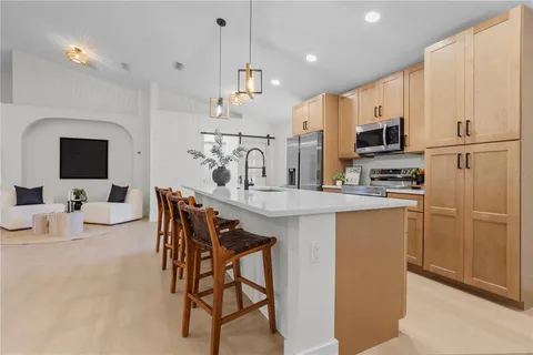 a kitchen with kitchen island a large counter top space appliances and cabinets