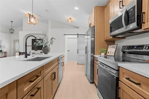 a kitchen with stainless steel appliances a sink stove and refrigerator