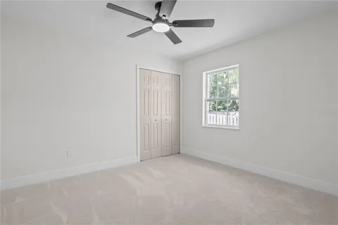 an empty room with a window and a fan