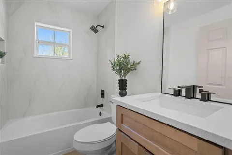 a bathroom with a sink a toilet a tub and shower