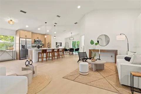 a living room with lots of furniture and a view of kitchen