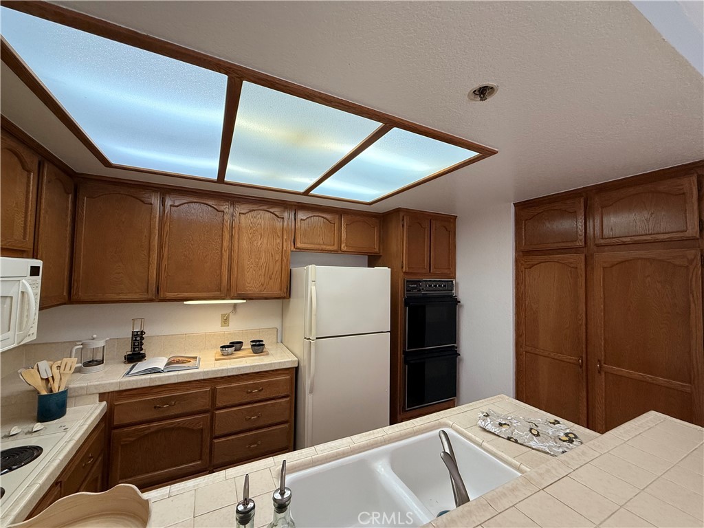 13601 Del Monte Drive, Unit 47A Seal Beach, CA 90740 - Photo 16 of 27 a kitchen with a refrigerator and a stove top oven