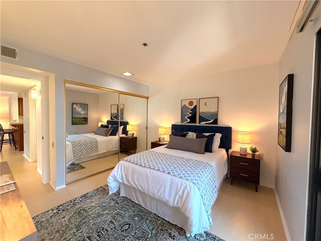 13601 Del Monte Drive, Unit 47A Seal Beach, CA 90740 - Photo 18 of 27 a bedroom with a bed and a mirror