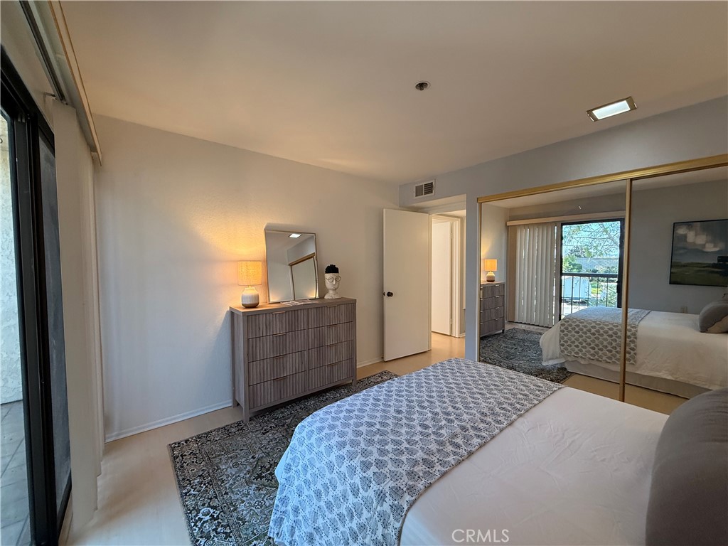 13601 Del Monte Drive, Unit 47A Seal Beach, CA 90740 - Photo 19 of 27 a bedroom with a bed and wooden floor