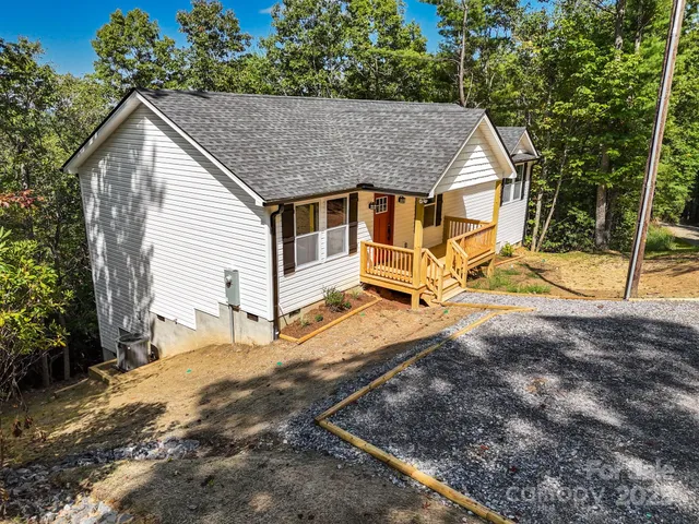 a view of a house with a yard and wooden fence