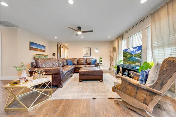 a living room with furniture and a wooden floor