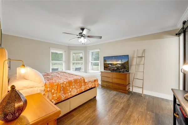 a spacious bedroom with a bed and a flat screen tv
